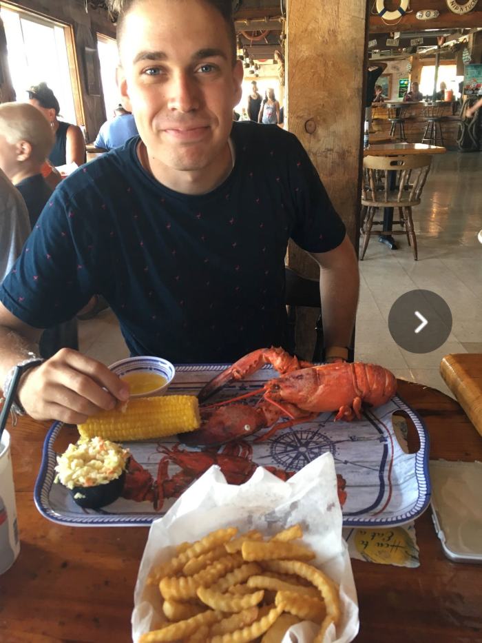 Dave with a whole steamed lobster, corn, coleslaw and fries at a Maine lobster shack