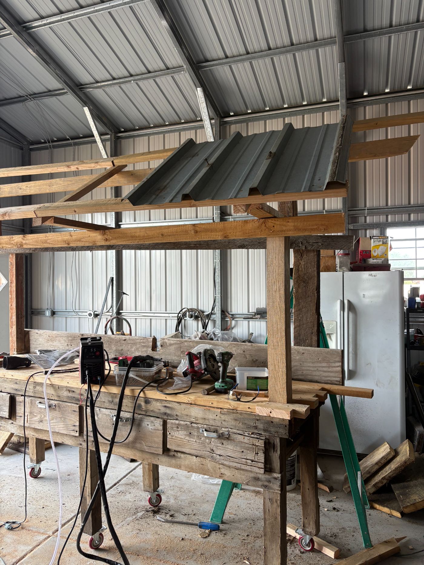 The tin roof frame going up over the workbench in the shop